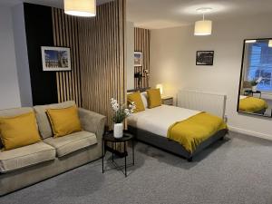 a bedroom with a bed and a couch at The Cozy Apartment in Gloucester