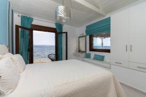 a bedroom with a bed and a view of the ocean at Villas Agapitos in Ayios Nikolaos Sithonia +48 photos