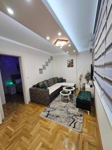 a living room with a couch and a table at Apartman Daluxst in Vrnjačka Banja