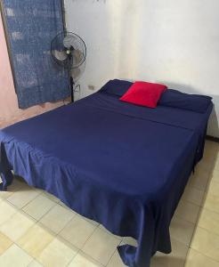 a blue bed with a red pillow on it at Apartamento frente al mar en Tanaguarenas in Caraballeda