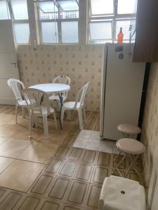 een kamer met een tafel en stoelen en een koelkast bij Apartamento na Pituba in Salvador