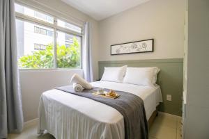 ein Schlafzimmer mit einem Bett, auf dem ein Tablett mit Essen steht in der Unterkunft JOA31 - 2 Dorm Climatizados, Garagem, TV Smart in Balneário Camboriú