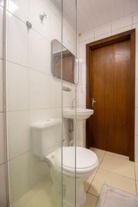 ein Badezimmer mit Toilette und Glastür in der Unterkunft JOA31 - 2 Dorm Climatizados, Garagem, TV Smart in Balneário Camboriú + 27 Fotos