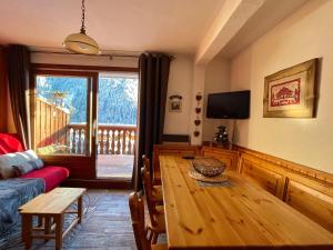 a living room with a wooden table and a couch at Appartement Chez Jean - 2 chambres - Centre du Village - À 30 mètres des télécabines in Champagny-en-Vanoise