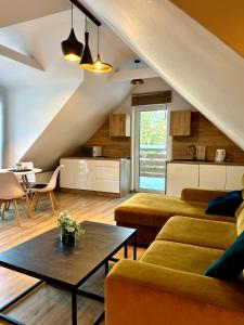 a living room with two couches and a table at Apartamenty Olimpijskie Szczyrk in Szczyrk