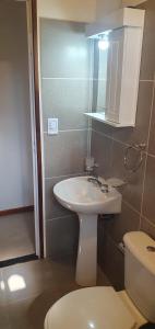 une salle de bain avec un lavabo blanc et des toilettes dans l'établissement Complejo Canto de los Pájaros, à Villa Parque Siquiman