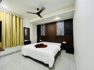 Un dormitorio con una cama y un ventilador de techo. en Hotel New Holiday Inn, en Ajra 7 fotos más