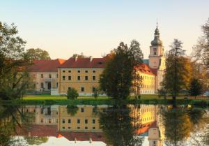 a large building with a reflection in the water at Apartament wiejska chata 150m2 in Piece