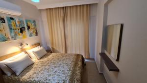 a hotel room with a bed and a flat screen tv at Bonito House 2 in Kemer