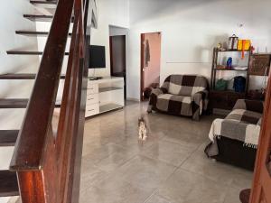a living room with a cat sitting on a tile floor at Casa de Praia - Coqueiro - Piauí in Luis Correia