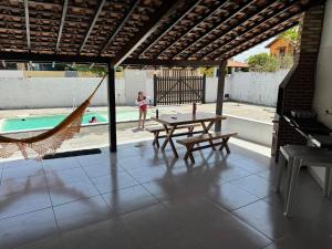 a patio with a hammock and a pool at Casa de Praia - Coqueiro - Piauí in Luis Correia