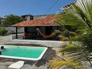 a child in a swimming pool next to a house at Casa de Praia - Coqueiro - Piauí in Luis Correia