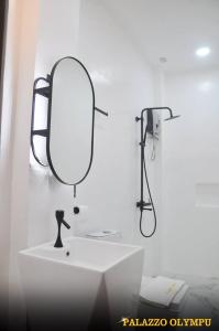 a bathroom with a sink and a mirror on the wall at Palazzo Olympu Guest House in Bantay