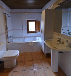 un bagno con vasca, WC e lavandino di Casa del Molí a Pontons