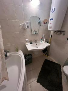 ein Badezimmer mit einer Badewanne, einem Waschbecken und einer Badewanne in der Unterkunft Bansko Aspen Relax & Chill in Bansko