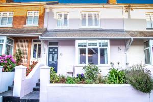 a white house with flowers in front of it at Stylish Padstow Townhouse in Padstow