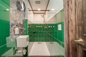 a green bathroom with a toilet and green tiles at The Harbor Hotel in Prescott +86 photos
