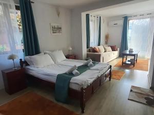 a bedroom with a large bed and a living room at Dvata Smurcha Central Apartments - Free Parking in Bansko
