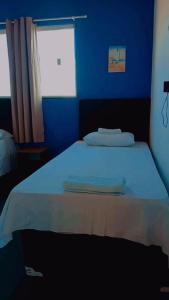 a blue bedroom with a bed with two towels on it at Chalé marlin azul in Icapuí