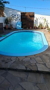 a large blue swimming pool in a yard at Pousada Vó Manuela in São Gabriel