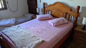 a bedroom with two beds with pink sheets at Pousada Vó Manuela in São Gabriel