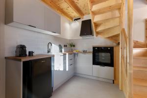 eine Küche mit weißen Schränken und einem schwarzen Kühlschrank in der Unterkunft Aetheria in Skala Eresou