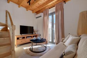 ein Wohnzimmer mit Sofa und Fernseher in der Unterkunft Aetheria in Skala Eresou