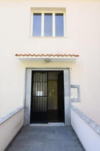 a white building with a black door and a window at 5 mins to the beach, cozy home in Rapallo