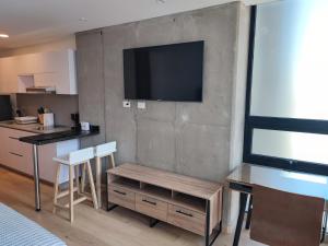 a living room with a television on a wall at ApartaSuite Centro Internacional in Bogotá