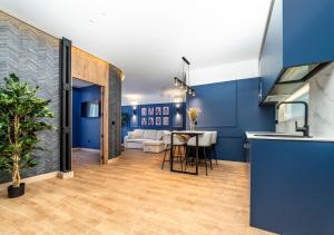 a kitchen and living room with blue walls and a table at Ando Apartments Suites in Salamanca