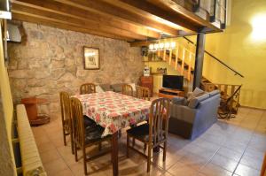a dining room with a table and a stone wall at Casa del Molí in Pontons
