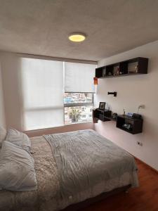 ein Schlafzimmer mit einem Bett und einem Fenster in der Unterkunft Modern and comfortable apartment nearby Aairport in Lima