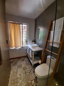 a bathroom with a toilet and a sink and a mirror at Hostal Suite Le Fabrique in Cuenca +127 photos