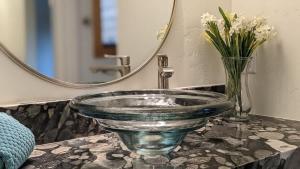 a glass bowl sink on a counter with a mirror at NEW Romantic LakeView Studio Beach Pool Modern in McCall