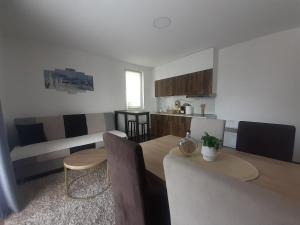 a kitchen and living room with a table and chairs at Apartmani Moskva in Kopaonik