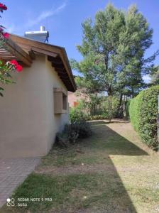 ein weißes Gebäude mit einem Seitenfenster in der Unterkunft Casa El ALto 1 in Villa General Belgrano