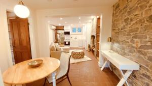 a dining room and living room with a stone wall at KingstonStays Historic Downtown Hideaway in Kingston