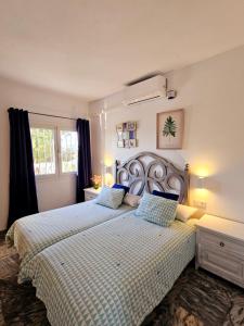 ein Schlafzimmer mit einem großen Bett mit blauen Kissen in der Unterkunft Casa mama lola in Fuengirola + 107 Fotos