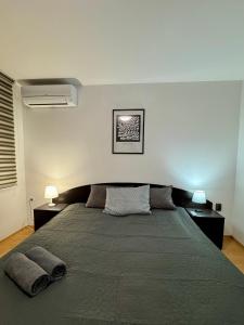a bedroom with a large bed with two tables and two lamps at Best Family Apartment in Varna City +39 photos