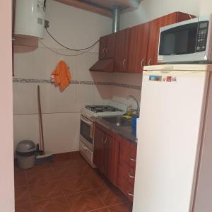 a small kitchen with a microwave and a refrigerator at LUCI Hospedaje in Uspallata
