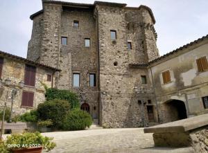 a large stone building with a large tower at LA BAITA di Ornaro Alto Rieti - oasi di pace tra Roma e Terminillo in Ornaro