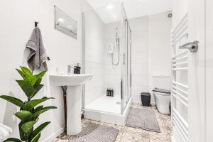 une salle de bain blanche avec une douche et un lavabo dans l'établissement Stylish Apartment in Coventry Center With Free Parking, à Parkside