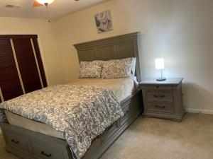 Un dormitorio con una cama y una mesita de noche con una lámpara. en LUX homes, en Fort Washington