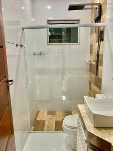 a bathroom with a shower and a toilet and a sink at Aconchegante casa em Marataizes in Marataizes