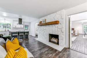a living room with a large stone fireplace at Woodsy Concord Retreat about 11 Mi to Nascar! in Concord