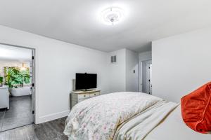 a white bedroom with a bed and a television at Woodsy Concord Retreat about 11 Mi to Nascar! in Concord