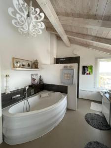 a large white tub in a bathroom with a chandelier at Architekten-Villa, moderne 220qm, 4 Schlafzimmer, Garten in Irschenberg +51 photos