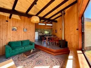 a living room with a green couch and a table at Huelemolle Lodge Pucón in Pucón