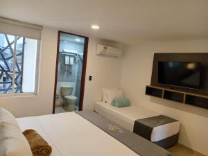 a hotel room with two beds and a flat screen tv at Buendía Hotel in Barrancabermeja