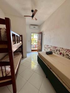 a bedroom with two bunk beds and a couch at Casa Boa Vida GuestHouse in Itacaré